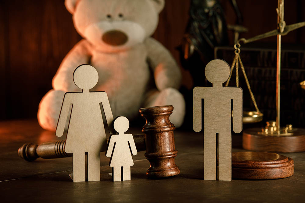 Wooden figures in front of judge's gavel and justice balance